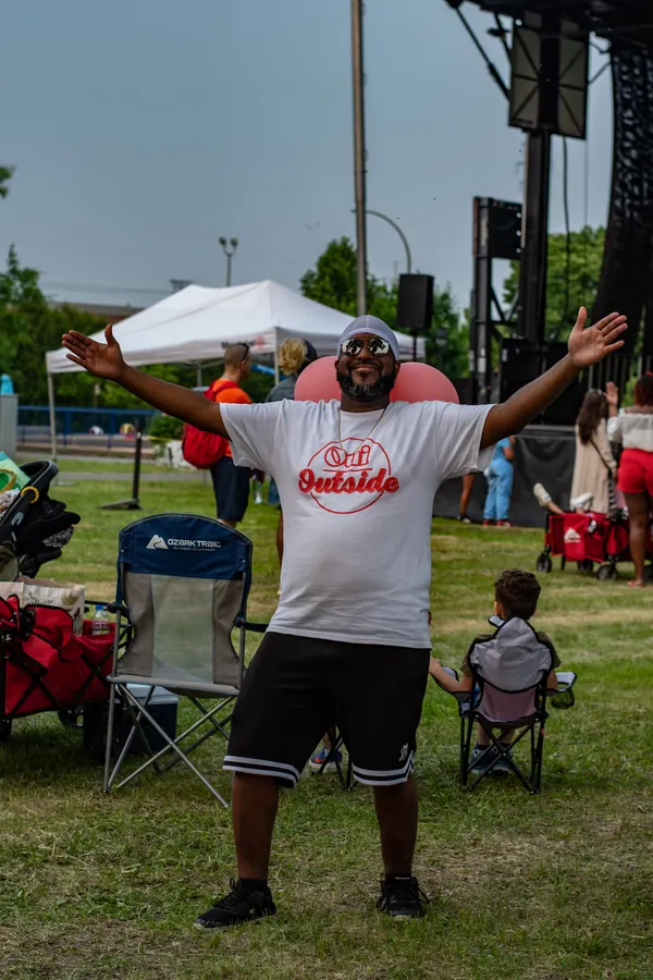 Un participant en t-shirt Oui Outside, les bras grands ouverts