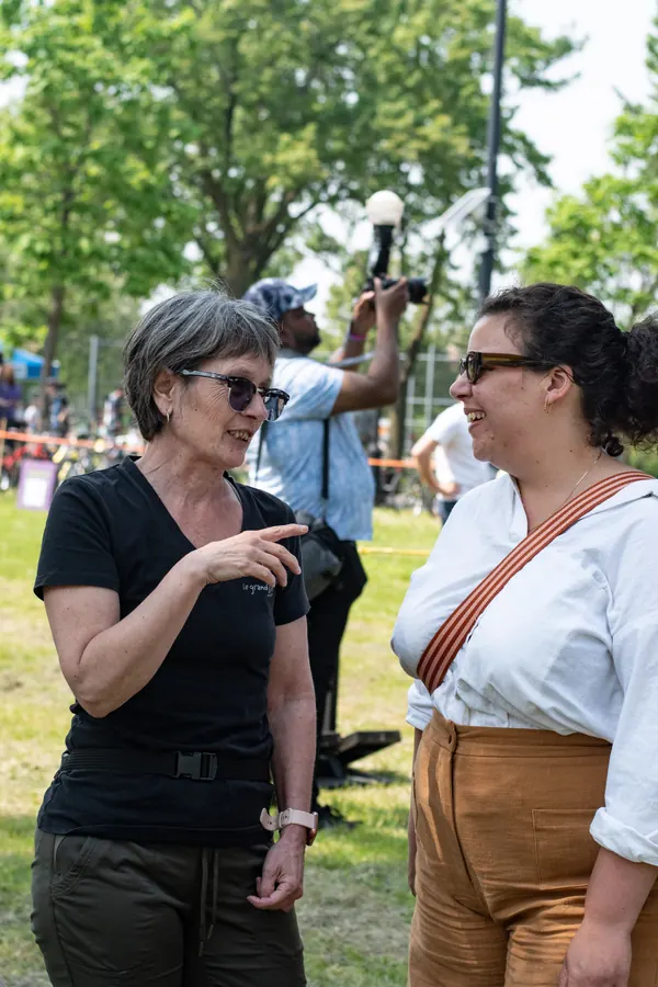 Deux festivalières discutent à l’ombre des arbres