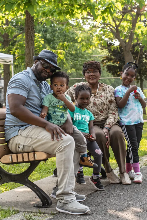 Un papa assis sur un banc avec des enfants du quartier